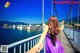 A woman in a purple dress holding hands on a bridge.