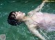 A woman in a pink bathing suit floating in the water.