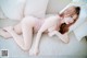 A woman laying on a couch in a pink lingerie.