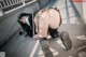 A woman in a school uniform is bending over on the ground.