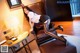 A woman sitting on a brown leather chair in a room.