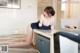 A woman sitting on top of a table next to a couch.