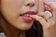 A close up of a woman's face with a ring on her finger.